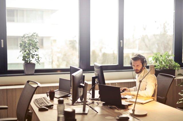 A man with headphones in an office.